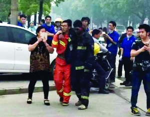 事故現場，受傷的消防隊員被隊友攙扶到一邊休息