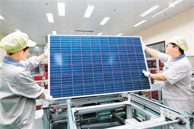 江蘇連云港神舟新能源有限公司工人在太陽(yáng)能光伏生產(chǎn)線上忙碌。