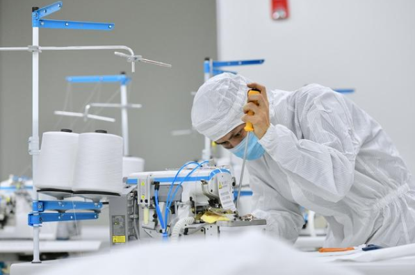 在位于晉江的福建海峽石墨烯產業技術研究院的無菌實驗室，技術人員在調試剛剛送達的防護服生產設備。新華社記者姜克紅攝